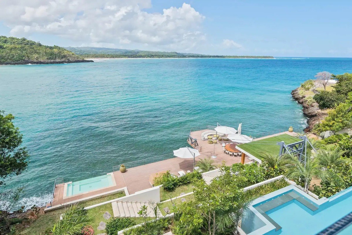 Oceanfront property has multiple pools, patio areas, and lush landscaping.