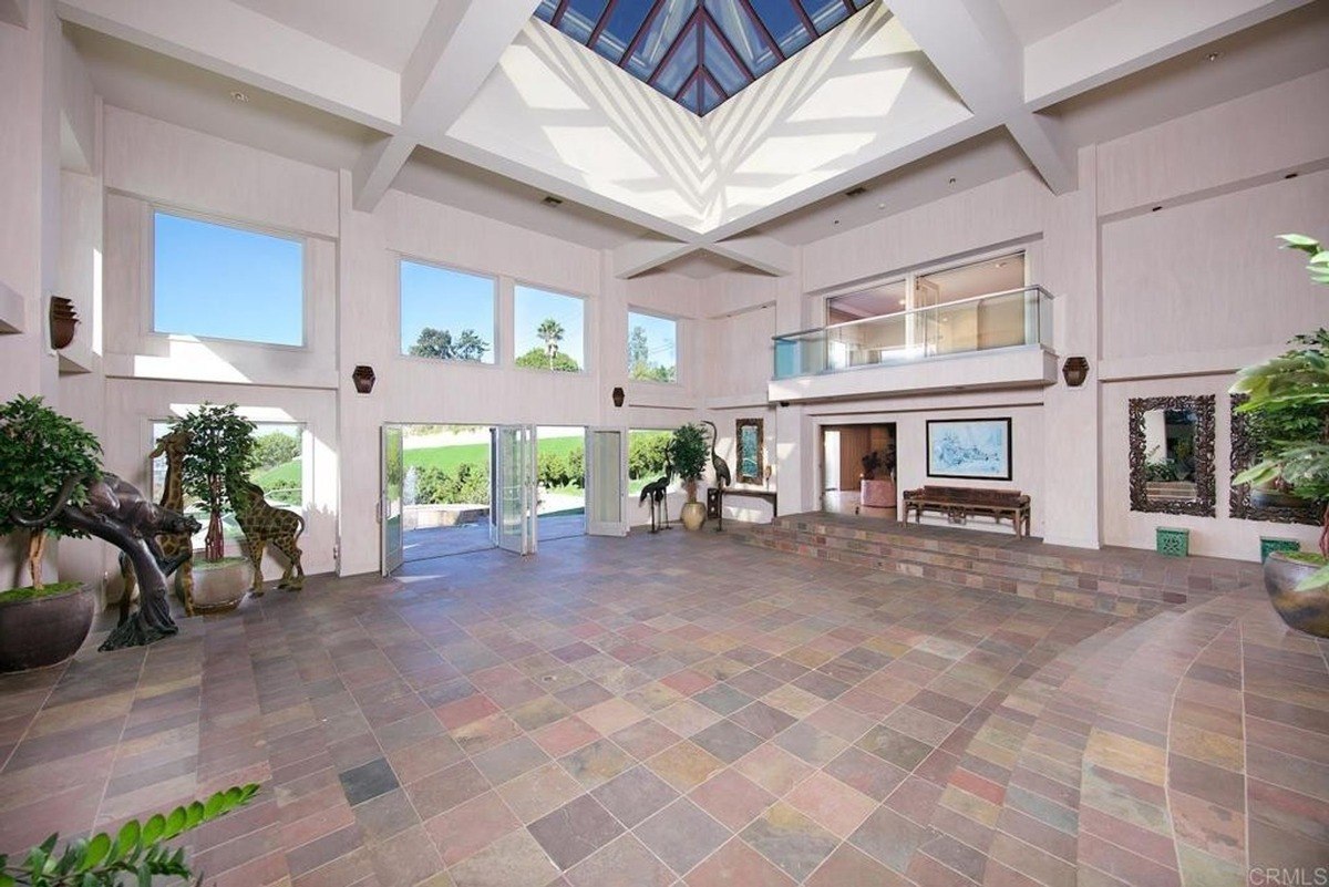 Expansive entrance hall with soaring ceilings, skylights, and large windows flooding the space with natural light.