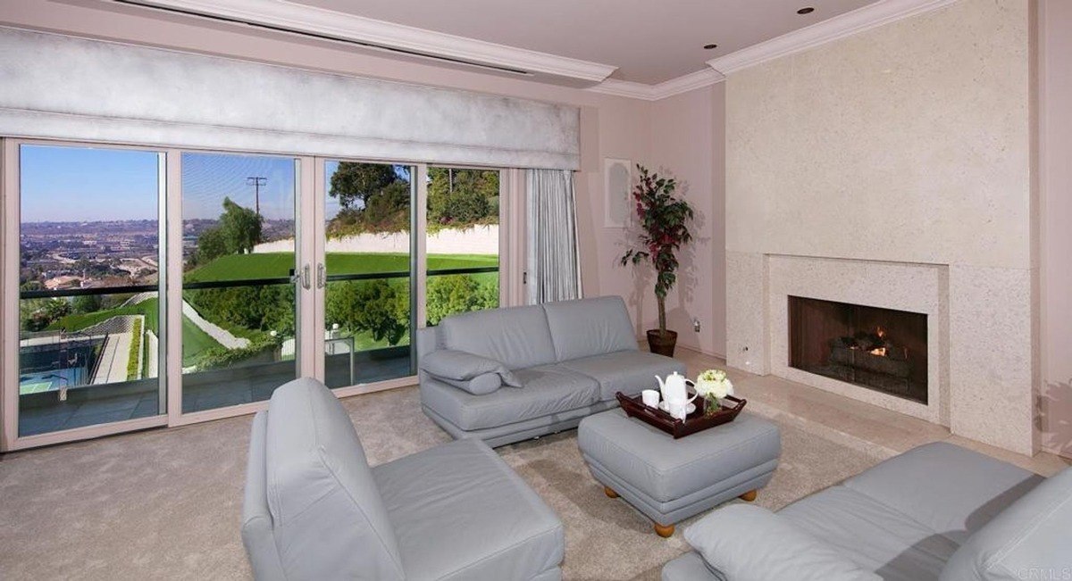 Cozy living room with large sliding glass doors opening to scenic views and a fireplace centerpiece.