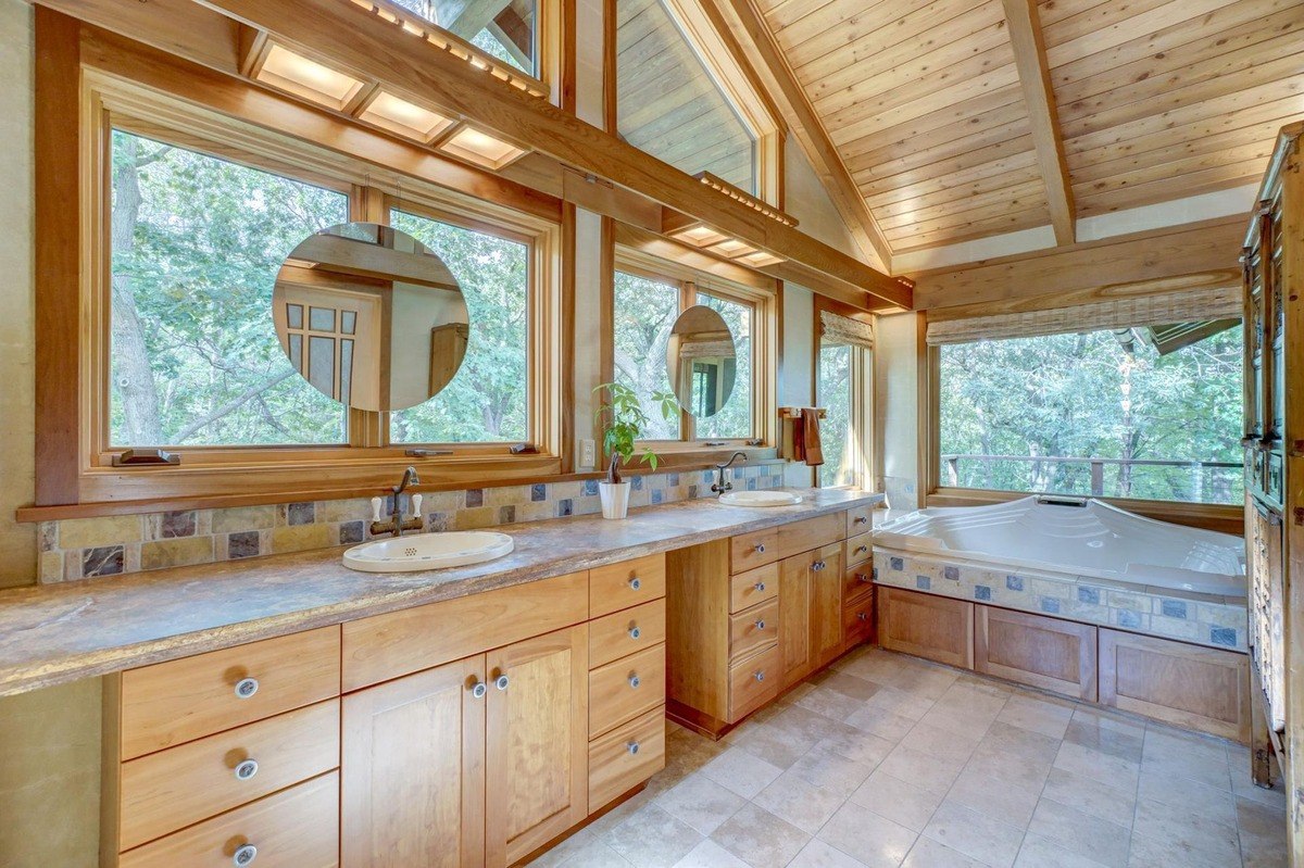 Luxurious bathroom with a spa-like feel features a large soaking tub, double vanity, and ample natural light, creating a relaxing retreat.