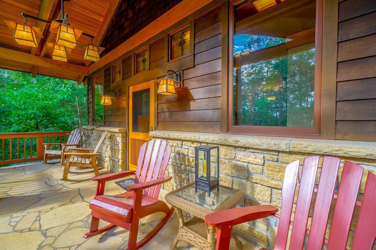 Cozy porch with rocking chairs, stone accents, and warm lighting offers a welcoming spot to relax and enjoy the outdoors.