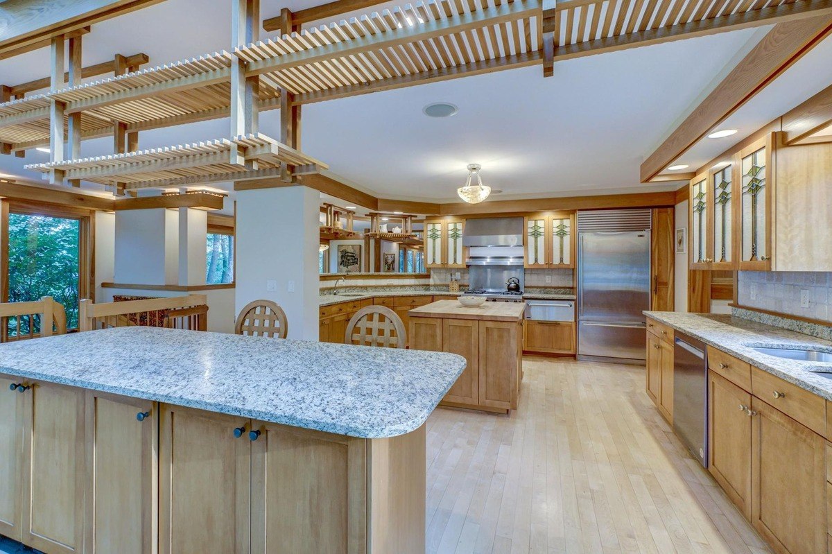 Warm wood tones and natural light create a welcoming atmosphere in this well-appointed kitchen, featuring a large island and plenty of storage space.