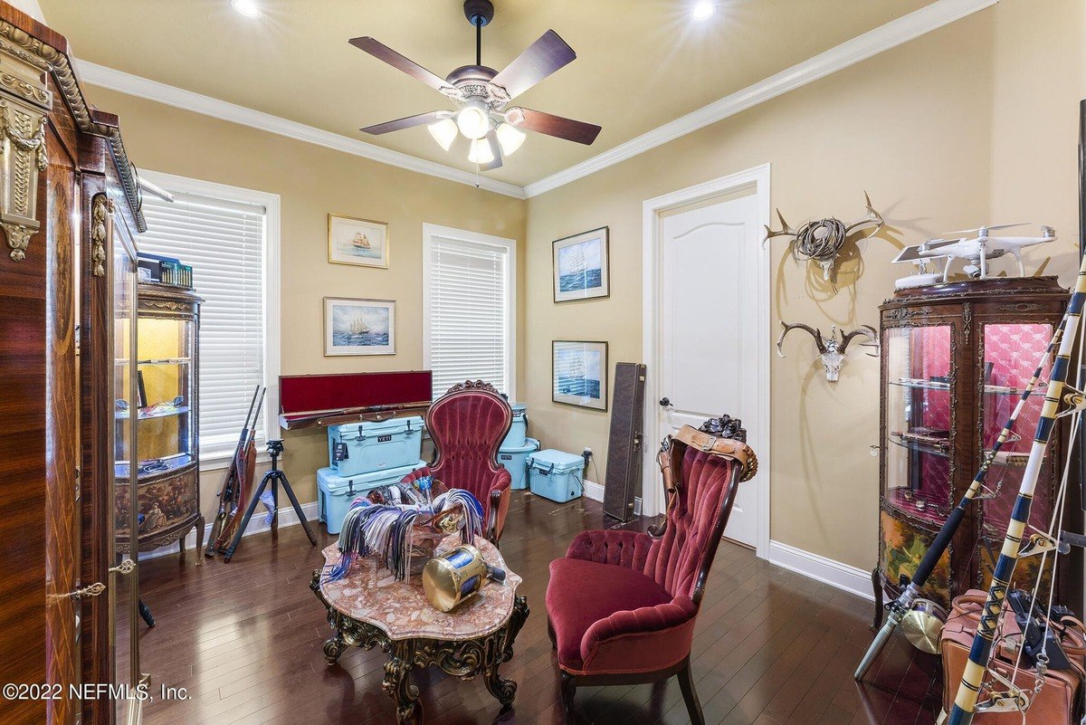 Room has dark wood floors, antique furniture, and nautical-themed decor.