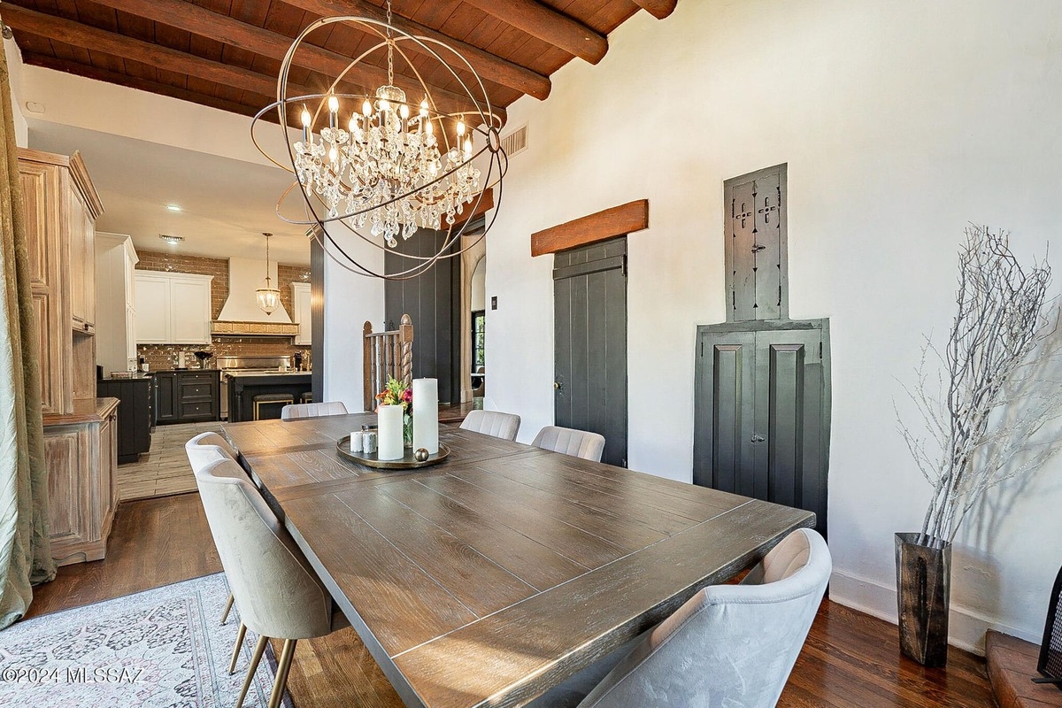 Bright dining space with wood floors, a large table, and sliding glass doors opening to the patio.