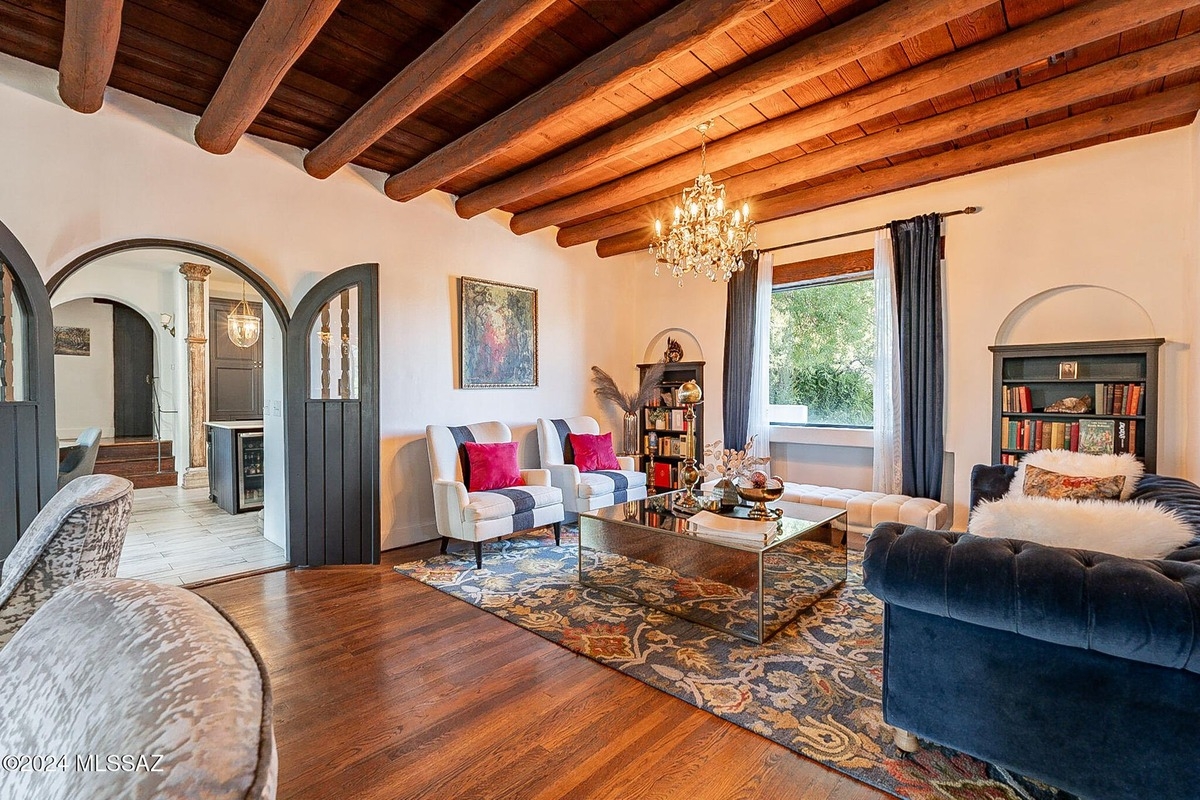 Open living space featuring wood flooring, bookcases, and decorative furnishings.