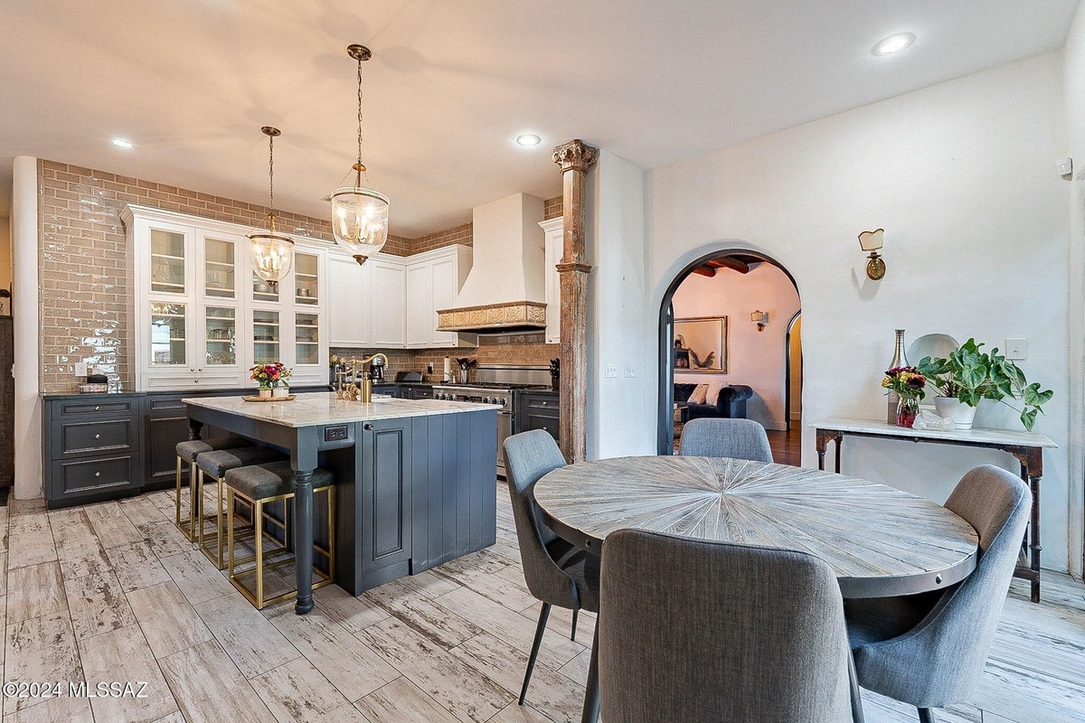 Elegant dining room with a chandelier, wood beams, and access to an outdoor space.