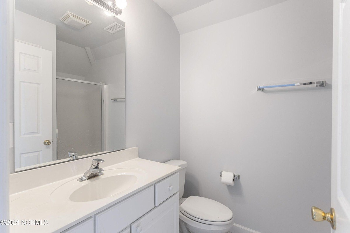 Bathroom has white cabinets, a toilet, and a shower.