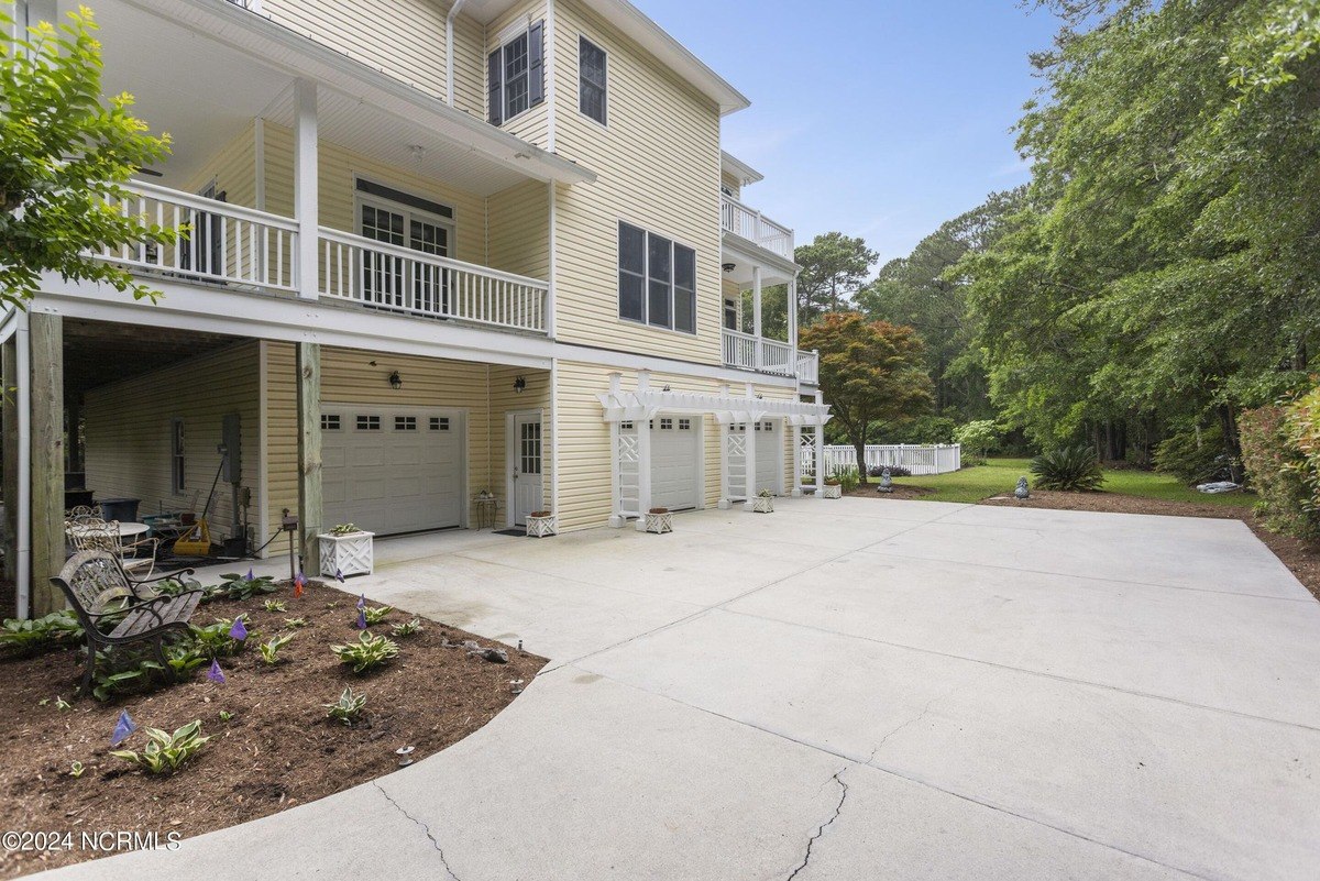 House has a large driveway, a three-car garage, and a balcony.