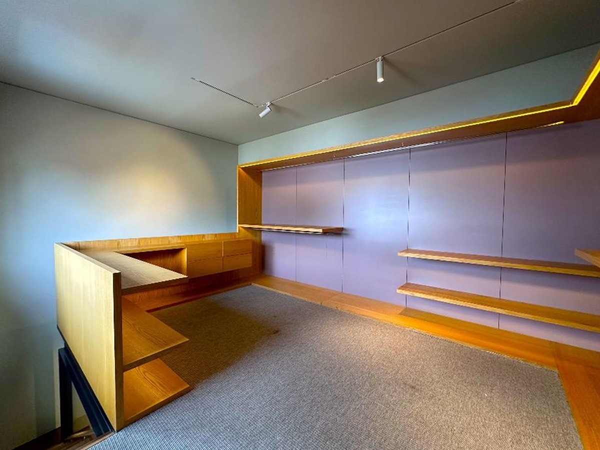 Built-in wooden desk and shelving system with a modern purple and natural wood finish.