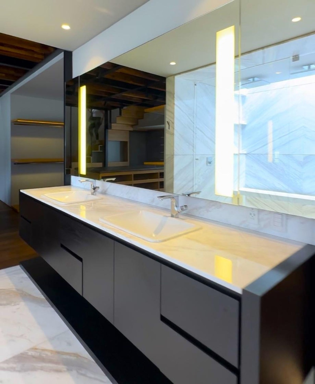 Double vanity bathroom with black cabinetry and large mirrors.