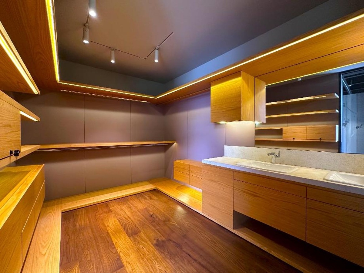 Walk-in closet with extensive shelving, wooden accents, and recessed lighting.