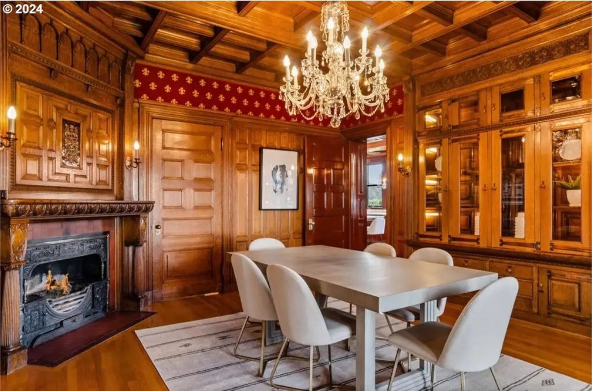 An intricately designed dining room featuring wood-paneled walls and a coffered ceiling.