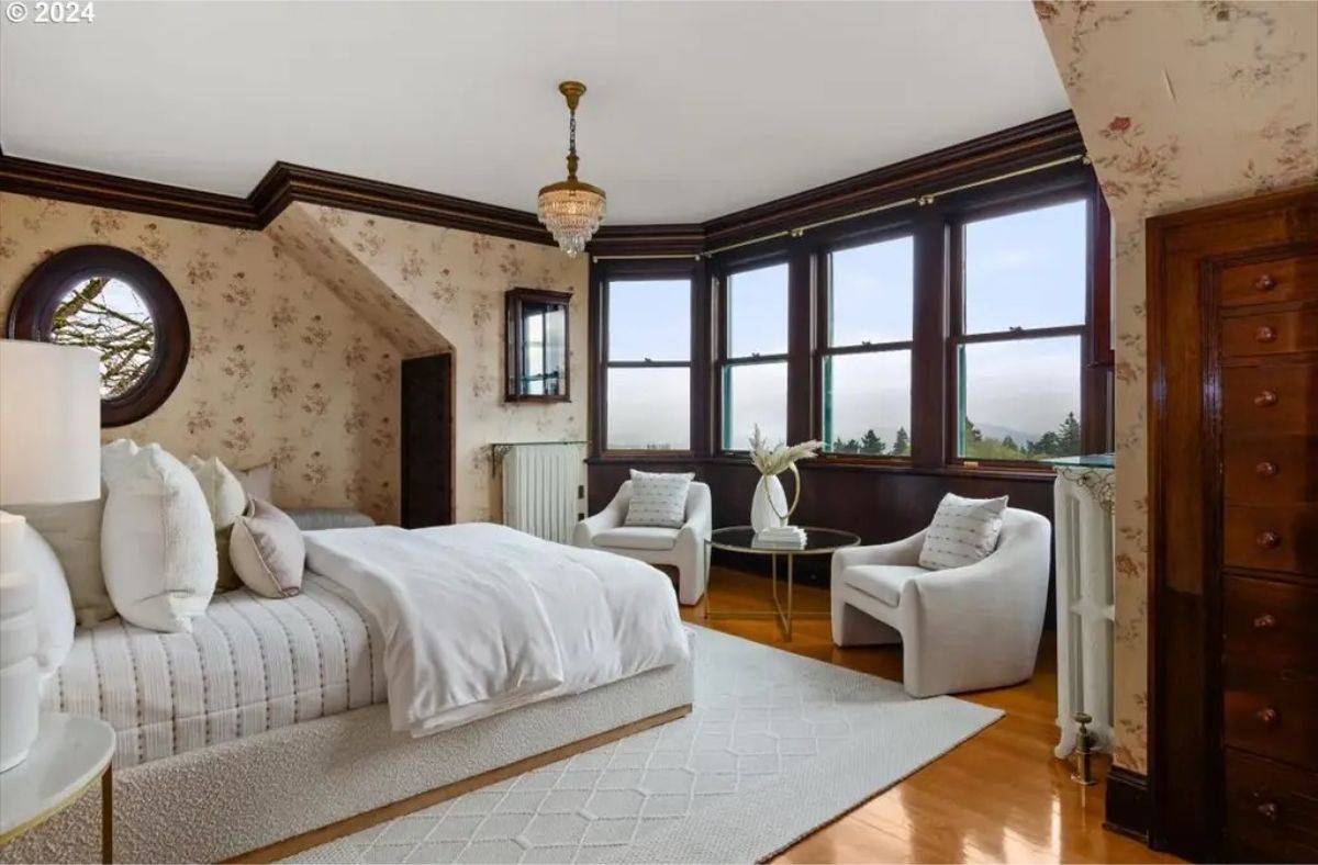 Bedroom with floral-patterned wallpaper and dark wood trim accents.