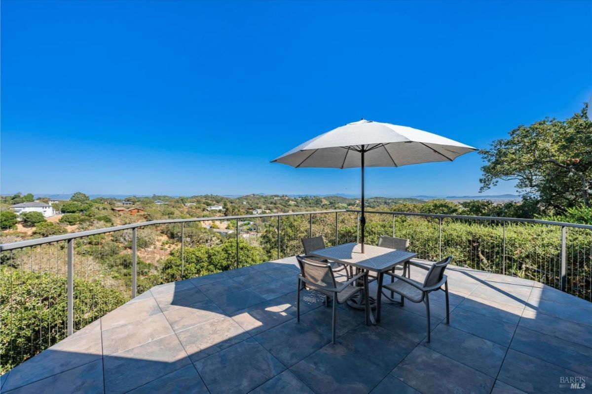 Patio with a table and chairs set up under a large umbrella.