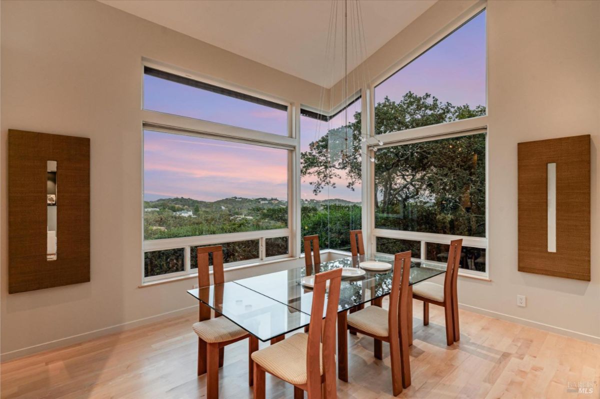 Bright dining space with panoramic windows showcasing scenic views.