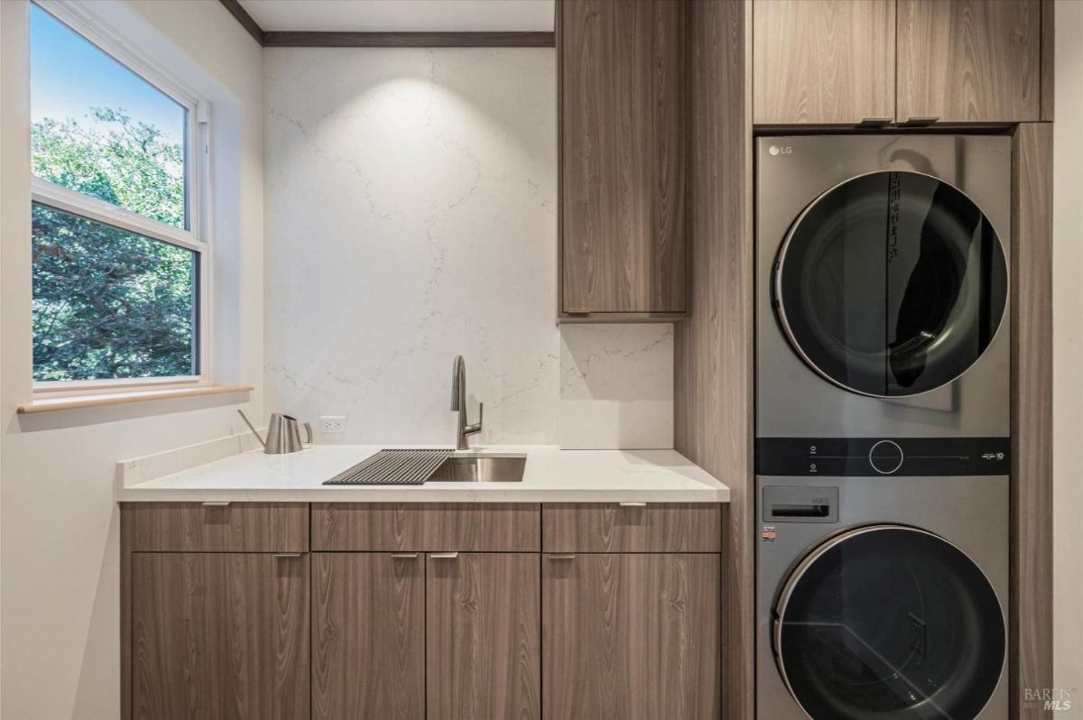 Ensuite laundry room with sink, countertop, and washer/dryer.