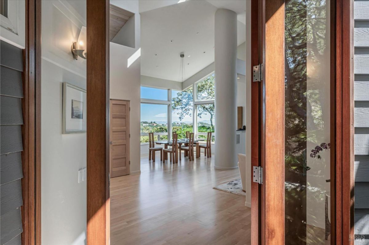 Entryway view showing a spacious interior with a dining area and outdoor scenery.