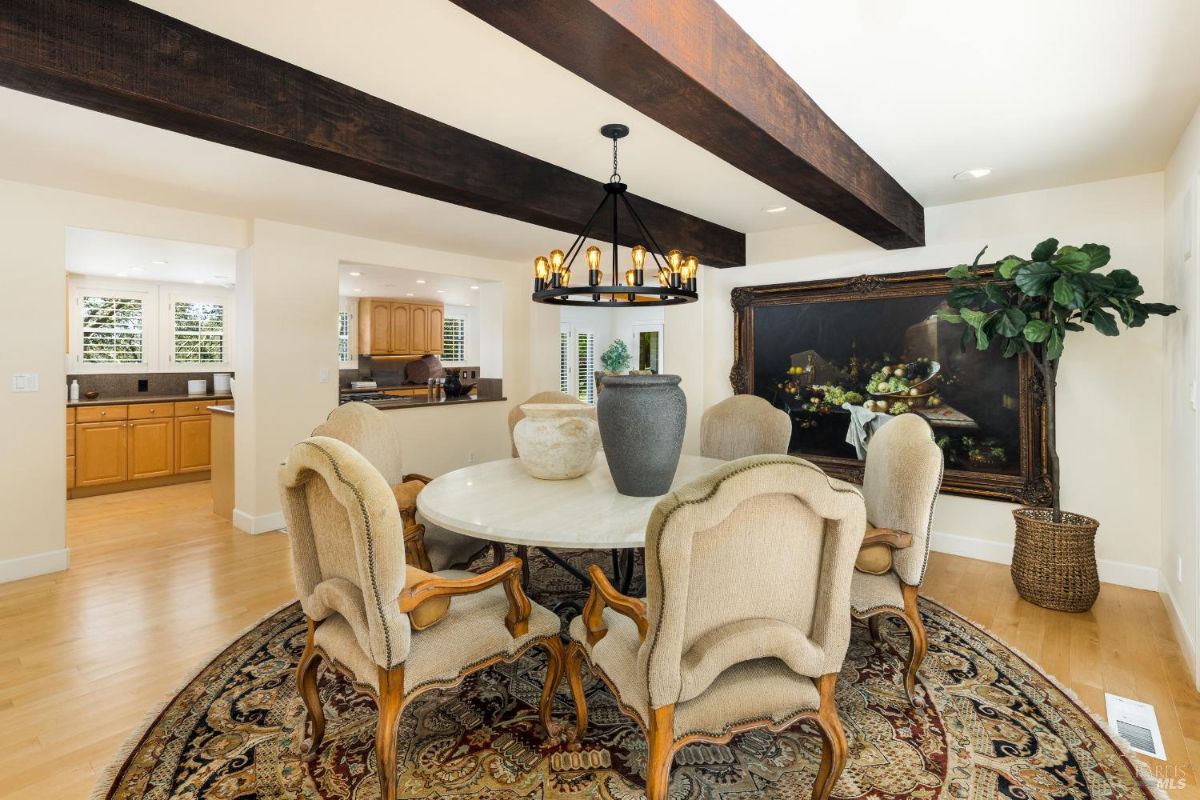 Dining area with a round table and a chandelier, adjacent to the kitchen.