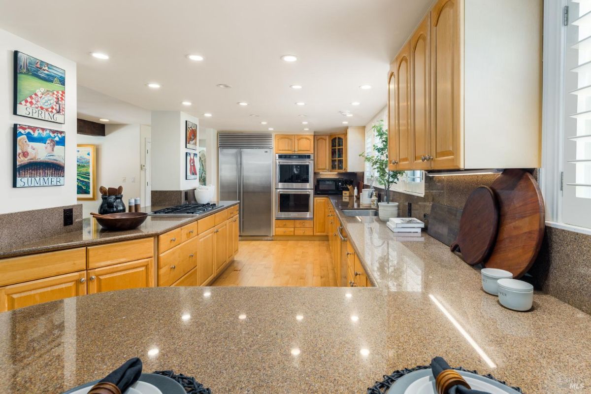 Spacious kitchen featuring wooden cabinets, granite countertops, and stainless steel appliances.