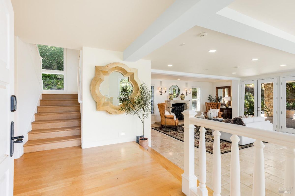 Entryway with a staircase, a large mirror, and a view of the living area.