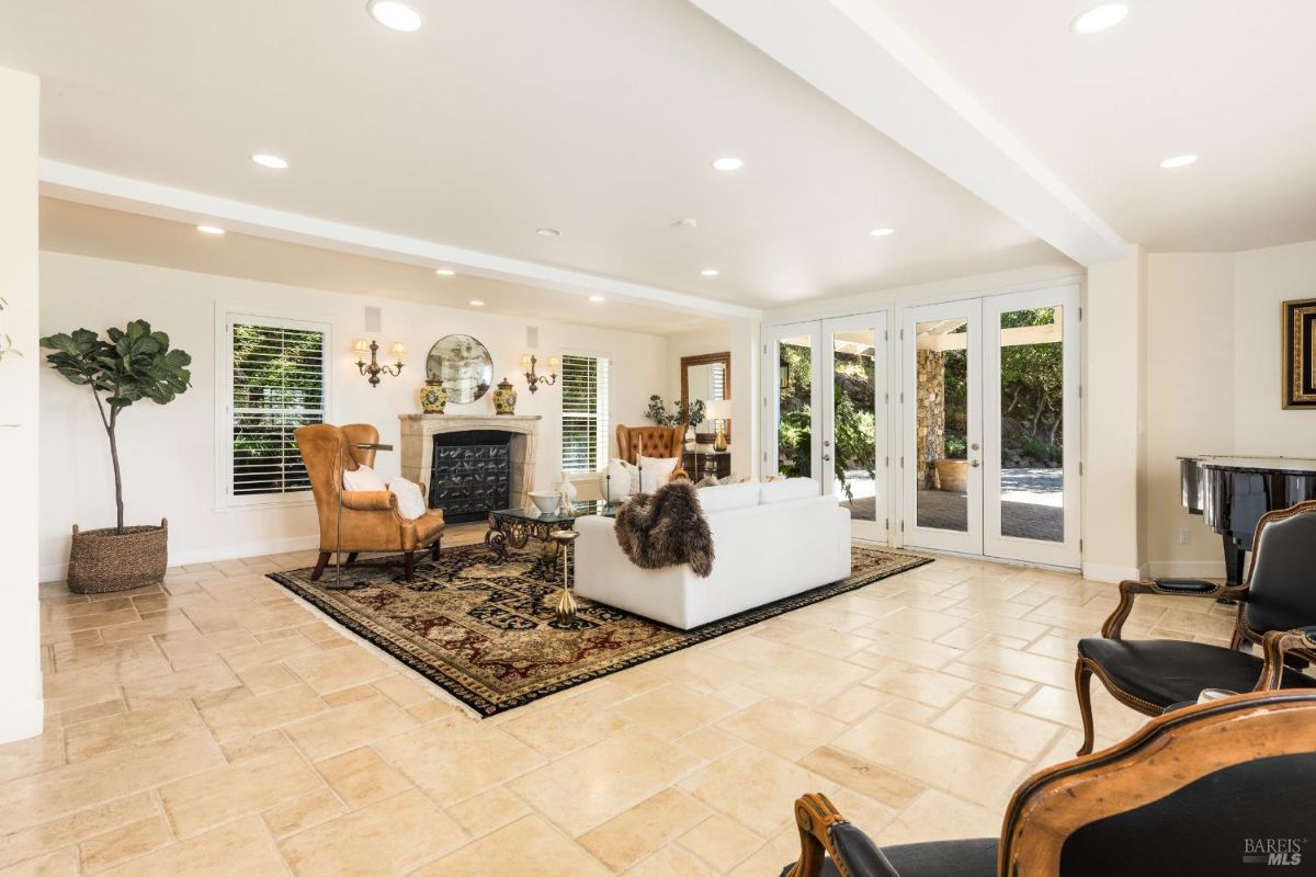 Bright living area featuring a fireplace, glass doors, and a tiled floor.