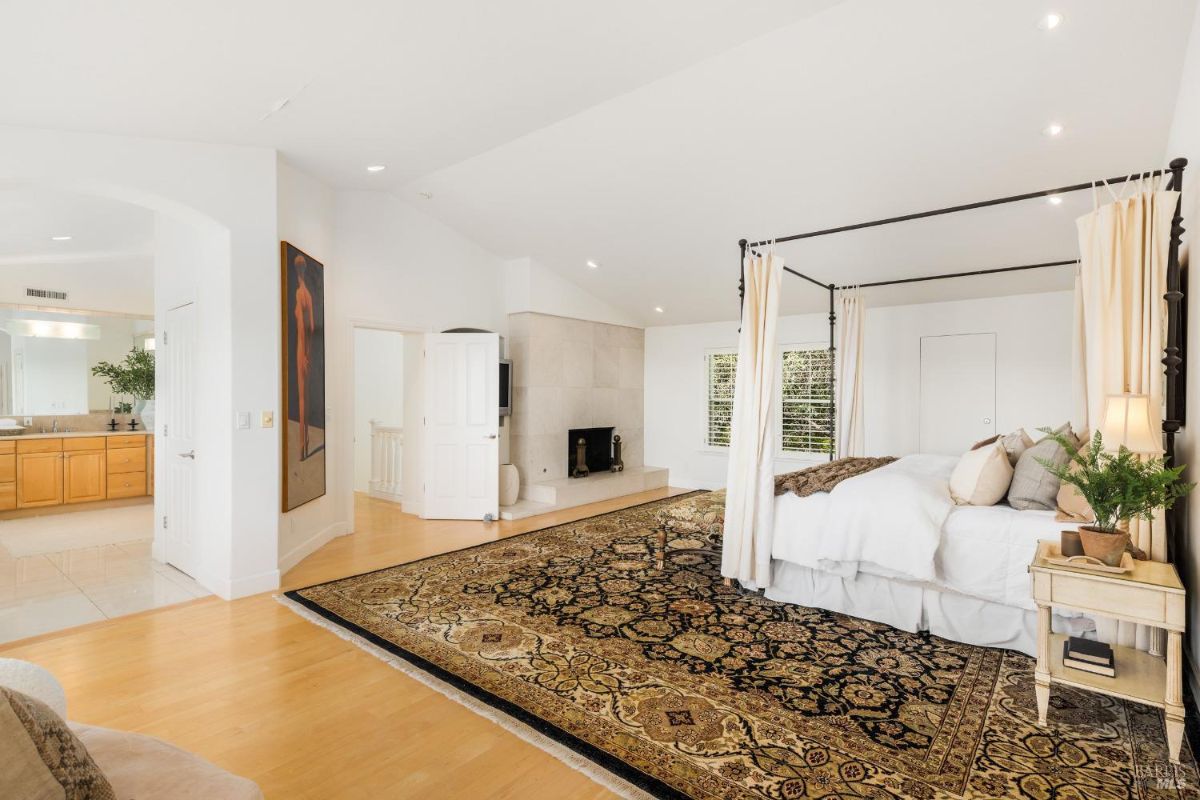 Master bedroom featuring a fireplace, open layout, and access to an ensuite bathroom.