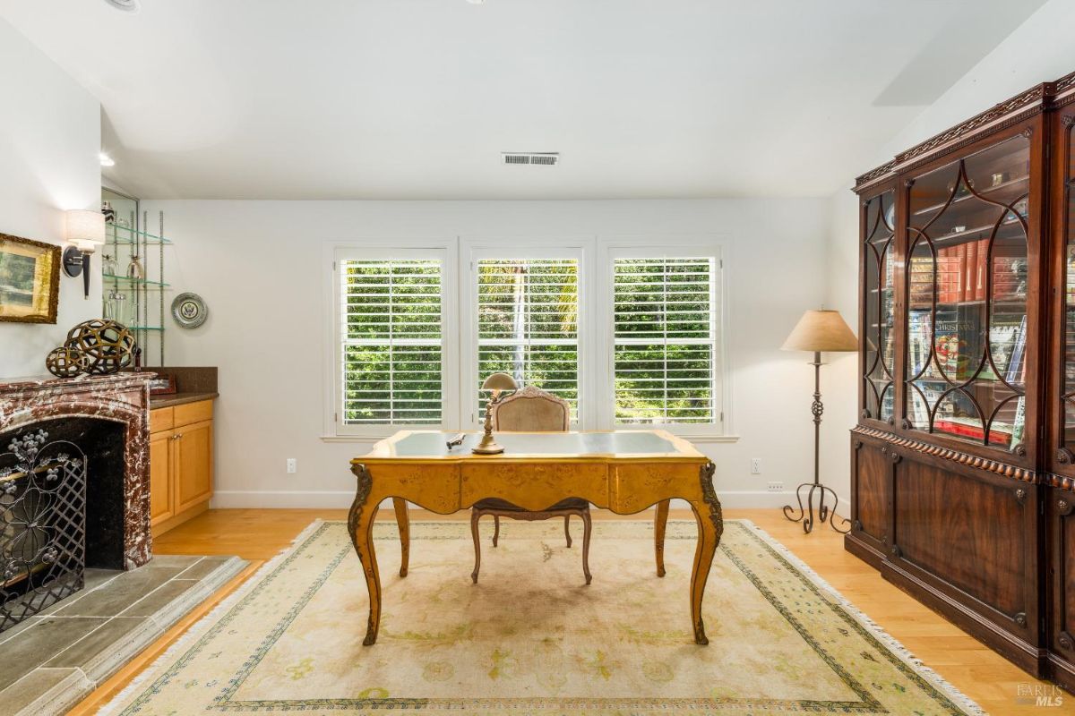 Office space includes a wooden desk, a large cabinet, and a decorative fireplace.