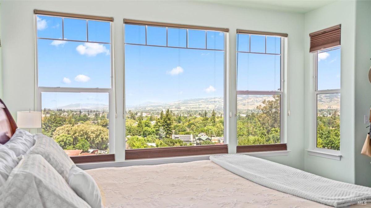 Close-up view of a bedroom showing large windows with panoramic outdoor views.