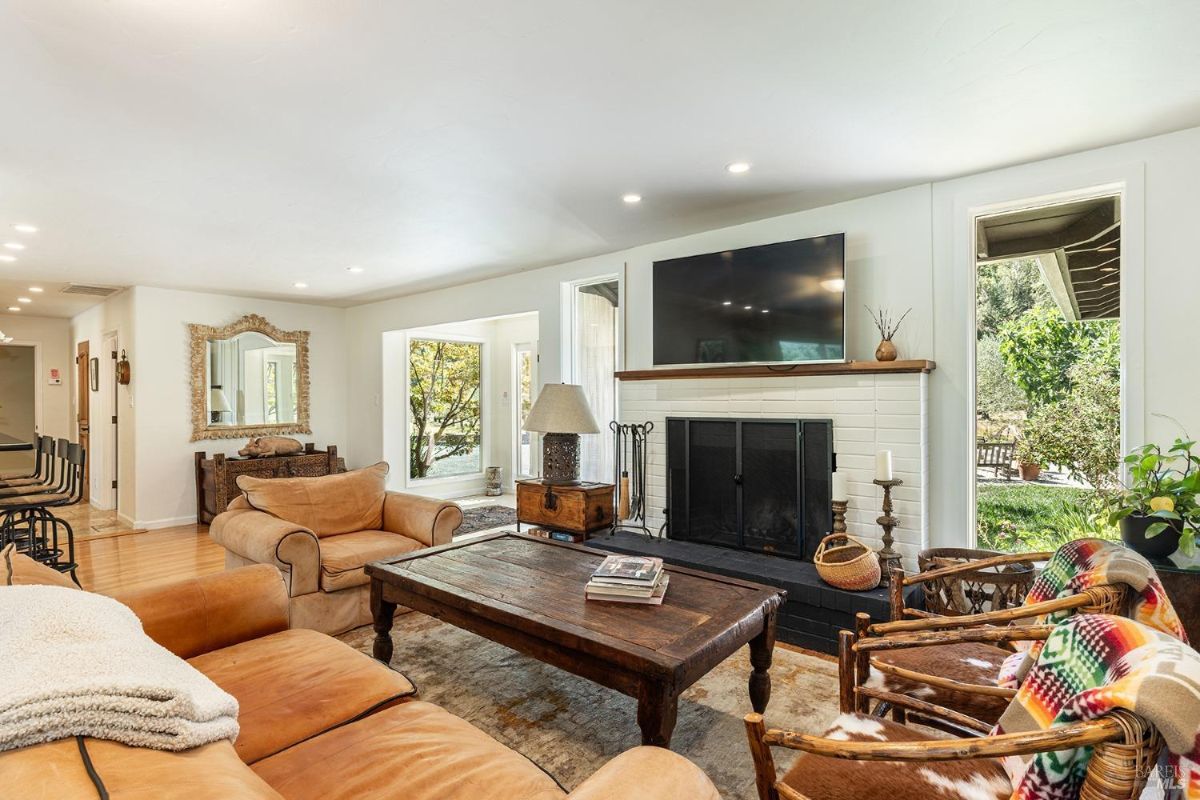 Living room with a fireplace, television, and rustic furniture in a cozy arrangement.