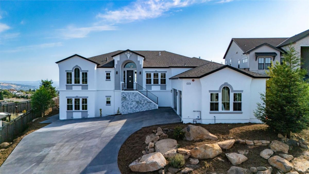 Modern white house with a large driveway and three-car garage.