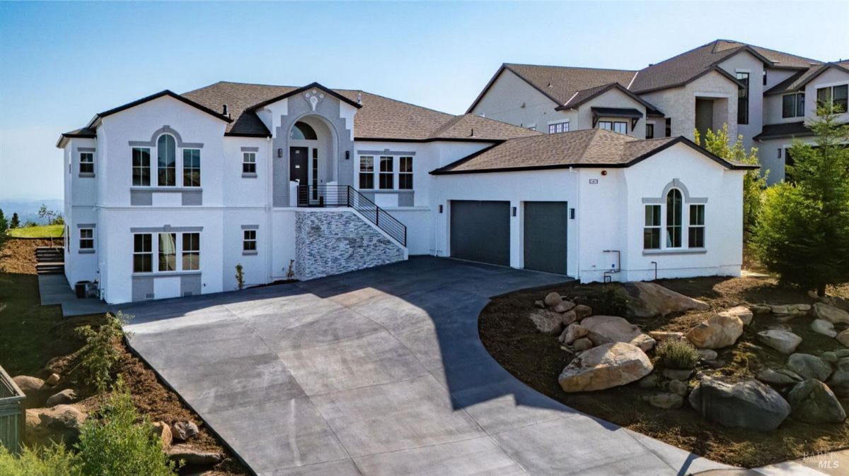 Modern white house with a large driveway and three-car garage.