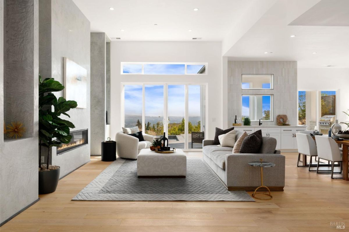 Spacious living room with a fireplace, large windows, and a view of the outdoors.