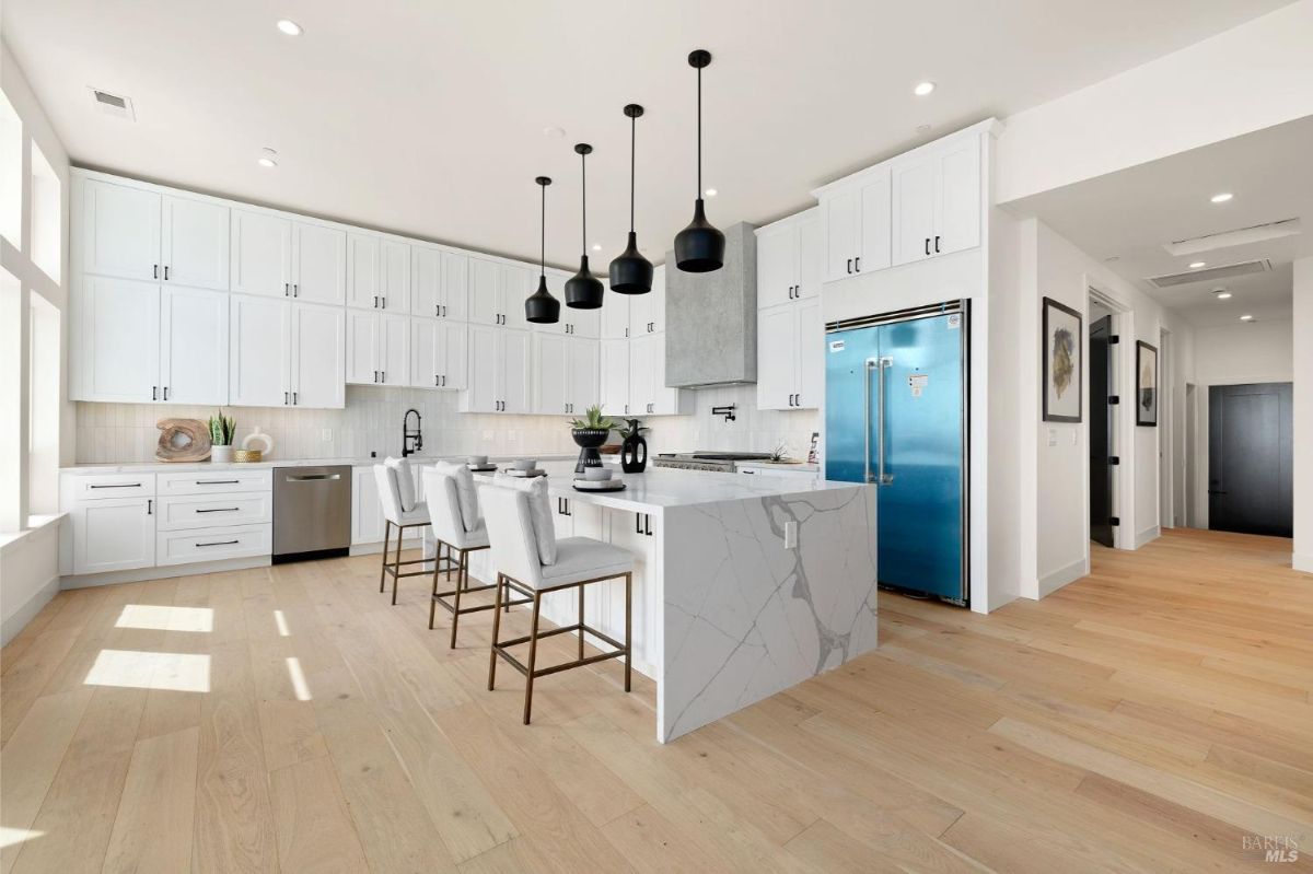 Kitchen area with sliding doors leading to an outdoor space and a marble countertop island.